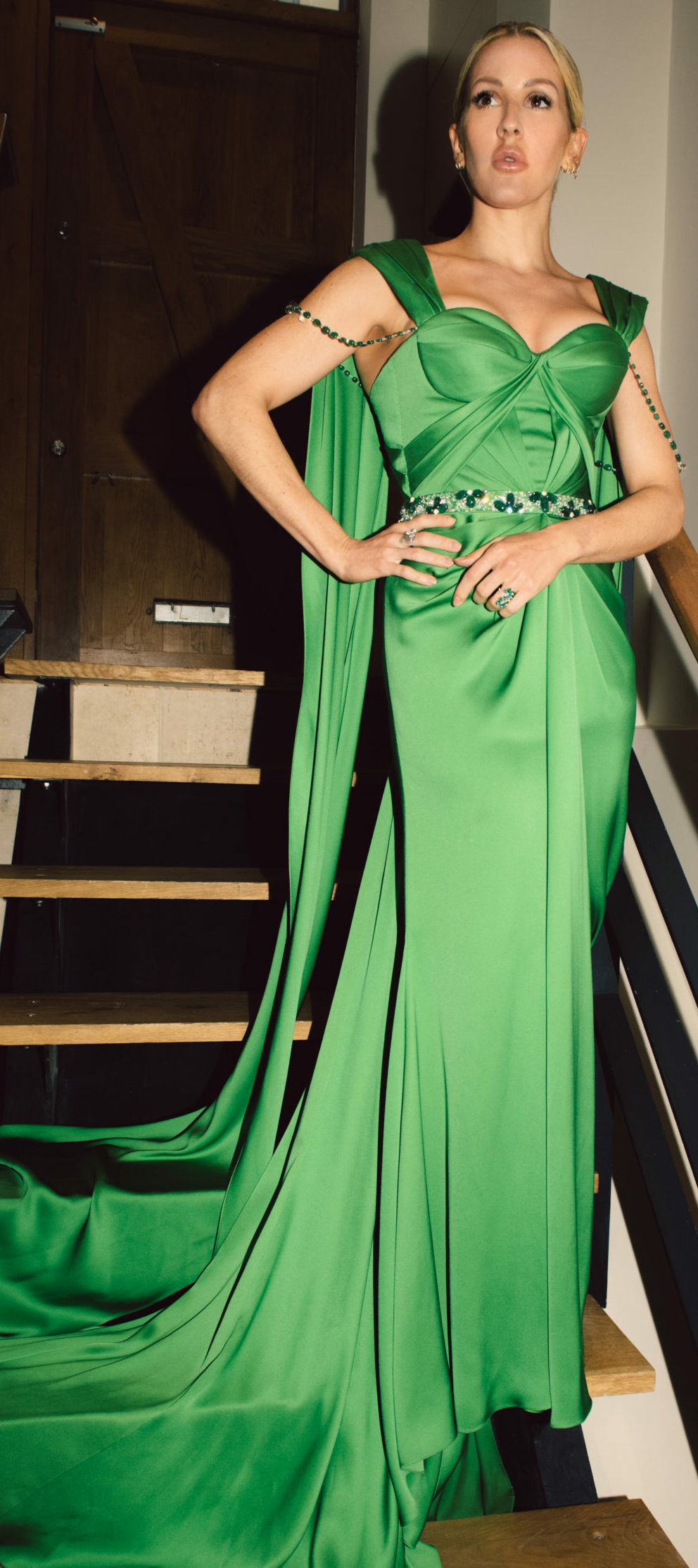 Ellie Goulding standing on stairs in dress green dress featuring Zambian emeralds from Ralph and Russo in Collaboration with Gemfields